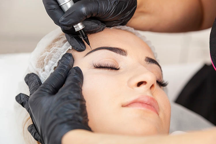 En kvinna får permanent makeup i sitt ansikte